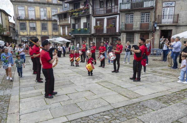 Traditional drum and pipe band perform on city streets on May Day 2025, Guimaraes, Braga district, northern Portugal
