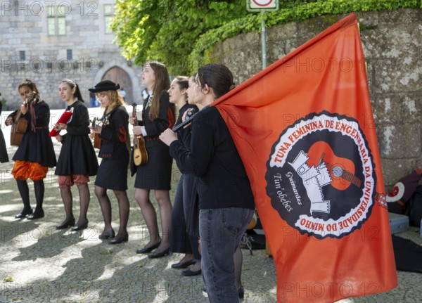 Group female university students musicians perform in street, city of Guimaraes, northern Portugal