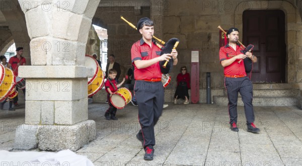 Traditional drum and pipe band perform on city streets on May Day 2025, Guimaraes, Braga district, northern Portugal