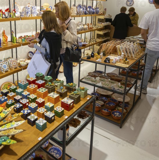 Shopping inside tourist souvenir craft shop selling pottery and ceramics, Guimaraes, northern Portugal