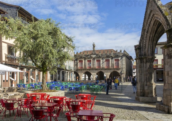 Tables and chairs, historic buildings in Largo da Oliveira square, city of Guimaraes, northern Portugal
