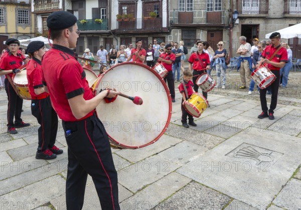 Traditional drum and pipe band perform on city streets on May Day 2025, Guimaraes, Braga district, northern Portugal