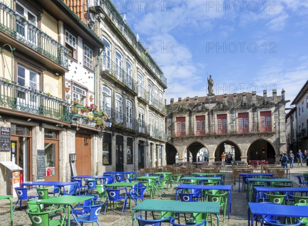 Tables and chairs, historic buildings in Largo da Oliveira square, city of Guimaraes, northern Portugal