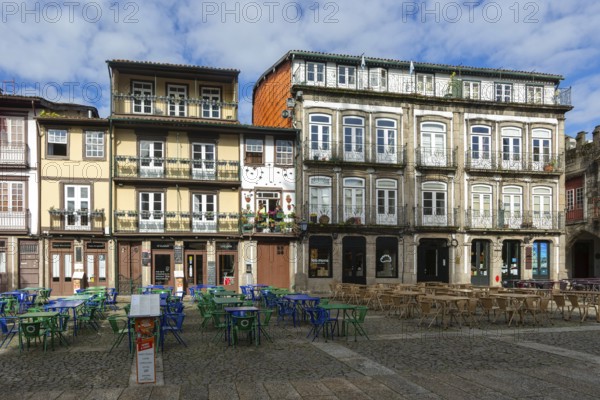Tables and chairs, historic buildings in Largo da Oliveira square, city of Guimaraes, northern Portugal