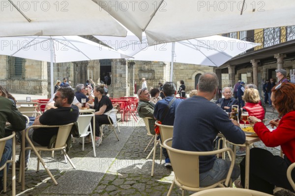 Customers sittimg outside at cafe tables, Largo da Oliveira square, city of Guimaraes, northern Portugal