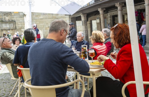 Customers sittimg outside at cafe tables, Largo da Oliveira square, city of Guimaraes, northern Portugal