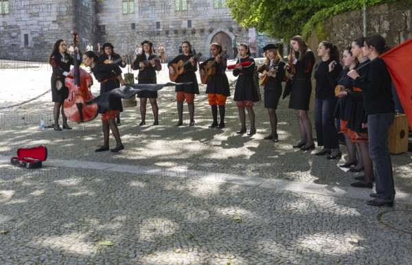 Group female university students musicians perform in street, city of Guimaraes, northern Portugal