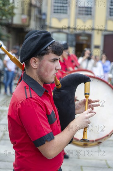 Traditional piper in band performing on city streets on May Day 2025, Guimaraes, Braga district, northern Portugal