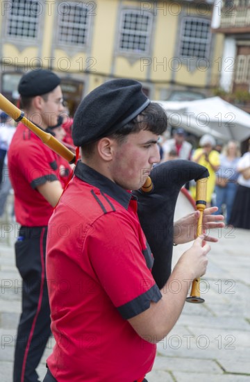 Traditional piper in band performing on city streets on May Day 2025, Guimaraes, Braga district, northern Portugal