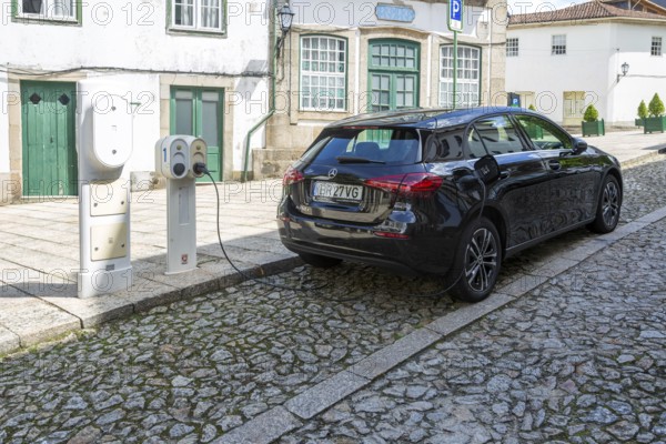 Mercedes-Benz hatchback car being recharged with electricity in city centre street, Guimaraes, northern Portugal