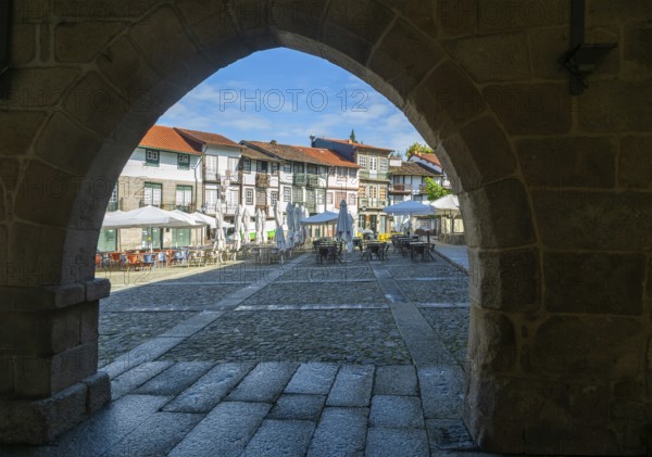 View through archway of historic buildings in Praça de São Tiago, city of Guimaraes, northern Portugal