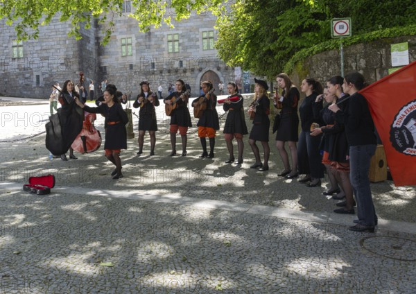 Group female university students musicians perform in street, city of Guimaraes, northern Portugal