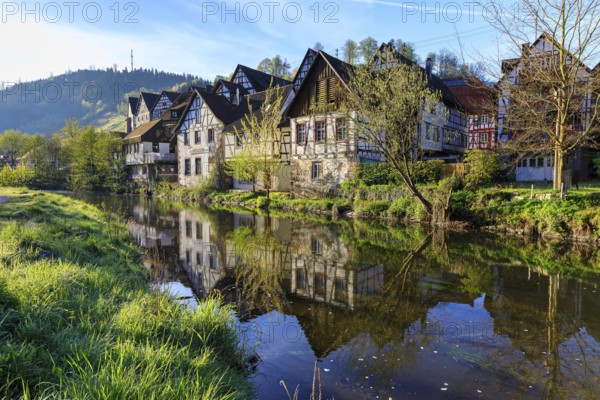 Historic half-timbered houses are reflected in the Kinzig, old town centre of Schiltach, Black Forest, Baden-Württemberg, Germany, Europe