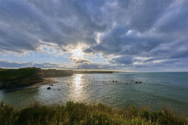 Sunrise over calm sea, dramatic clouds and light reflections, Opunake, Taranaki, North Island, New Zealand, Oceania