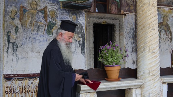 Priest with traditional robe in an interior with mural painting, Monastery of St John the Theologian, Monastery of St John the Theologian, World Heritage Site 1999, Patmos, Dodecanese, Greek Islands, Greece, Europe