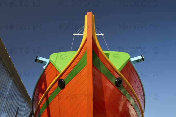 Close-up of the bow of a large orange boat in front of a clear sky, Diakofti boatyard, new construction of a coloured wooden boat, Diakofti, Patmos, Dodecanese, Greek Islands, Greece, Europe