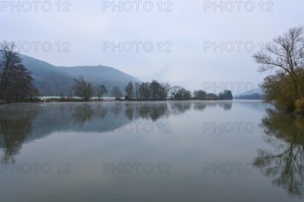 Foggy dawn over a calm river with hills and trees, Laudenbach, Main, Spessart, Odenwald, Bavaria Germany