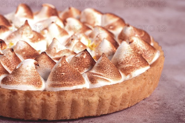 Lemon meringue cake, golden brown, toasted, on a light table, no people