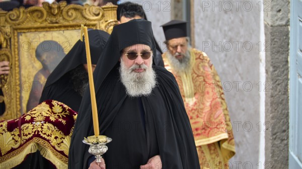 A priest in a black robe carries a candle next to an icon during a religious procession, Orthodox ceremony, monks of St John's Monastery, ceremonial washing of feet, procession, Maundy Thursday, Megali Pempti, Chora, Patmos, Dodecanese, Greek Islands, Greece, Europe
