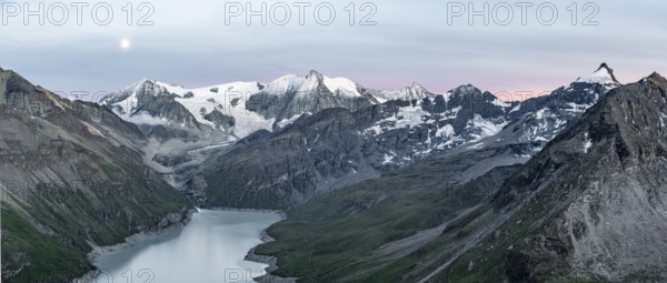 Mountain landscape with turquoise blue reservoir Lac des Dix and summit Mont Blanc de Cheilon, moon above mountain peaks at sunset, Hérménence, Valais Alps, Valais, Switzerland, Europe