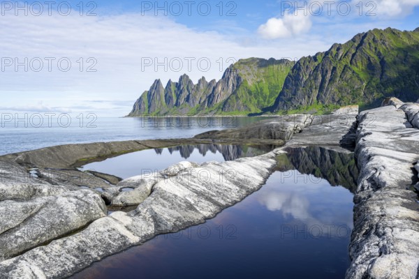 Reflection in a tidal pool, rocky coast of Tungeneset, Devil's Teeth, Okshornan, Ersfjorden, Senja Island, Troms, Norway, Europe