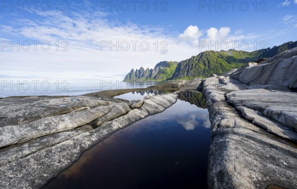 Reflection in a tidal pool, rocky coast of Tungeneset, Devil's Teeth, Okshornan, Ersfjorden, Senja Island, Troms, Norway, Europe