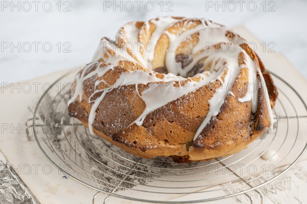 Marble bundt cake, cake with icing on a cake rack, light background