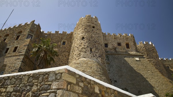 Medieval stone castle with palm trees and blue sky, imposing architecture, Monastery of St John the Theologian, Monastery of St John the Theologian, World Heritage Site 1999, outer wall, southern wall, Chora, Patmos, Dodecanese, Greek Islands, Greece, Europe