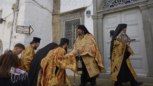 Priests in gold and black robes enter a door during a procession, Orthodox ceremony, monks of St John's Monastery, ceremonial washing of feet, procession, Maundy Thursday, Megali Pempti, Chora, Patmos, Dodecanese, Greek Islands, Greece, Europe
