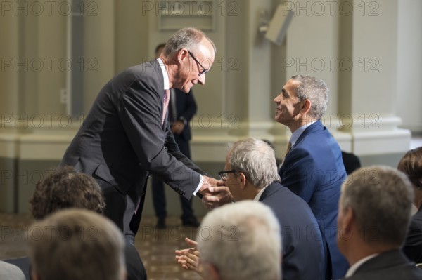 Friedrich Merz (Chancellor of the Federal Republic of Germany) congratulates Ugur Sahin (founder of Biontech SE) after receiving the German National Prize 2025 at the Französische Friedrichstadtkirche, Berlin, on 10 June 2025