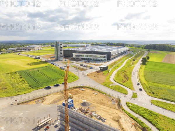 Industrial plant in sunshine with surrounding fields and a construction crane, ING Park development area, Zweckverband INGpark Nagold Gäu, Nagold, Germany, Europe