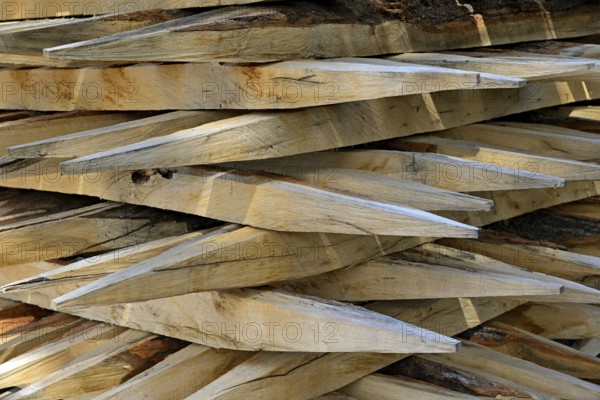 Stacked fence posts with sharpened ends. North Rhine-Westphalia, Germany, Europe