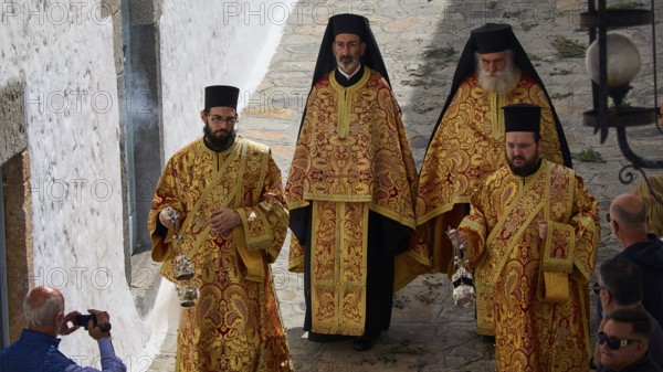 Four clerics in splendid gold robes walk down a narrow alley surrounded by spectators, Orthodox ceremony, monks of St John's Monastery, ceremonial washing of feet, procession, Maundy Thursday, Megali Pempti, Chora, Patmos, Dodecanese, Greek Islands, Greece, Europe