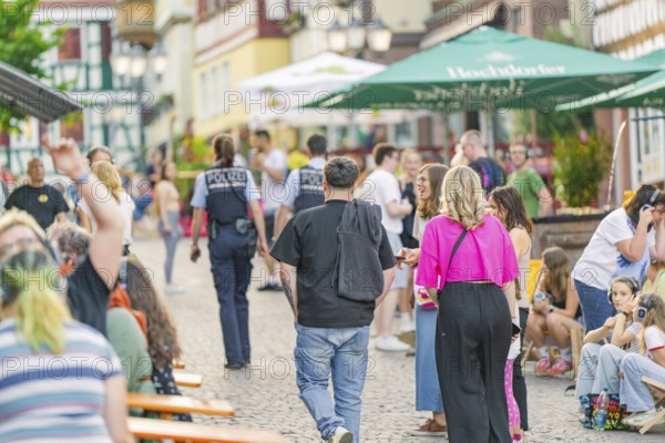 Street scene with people and policemen during a summer entertainment in the city, railway station festival Calw, Black Forest, Germany, Europe