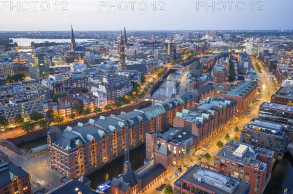 Aerial view of the Speicherstadt Hamburg at blue hour with churches and Alster in the background, Hamburg, Germany, Europe