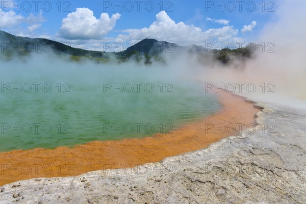 Bubbling mineral spring with steam and surrounded by mountains, Champagne Pool thermal lake, Wai-O-Tapu Thermal Wonderland, Rotorua, North Island, New Zealand, Oceania