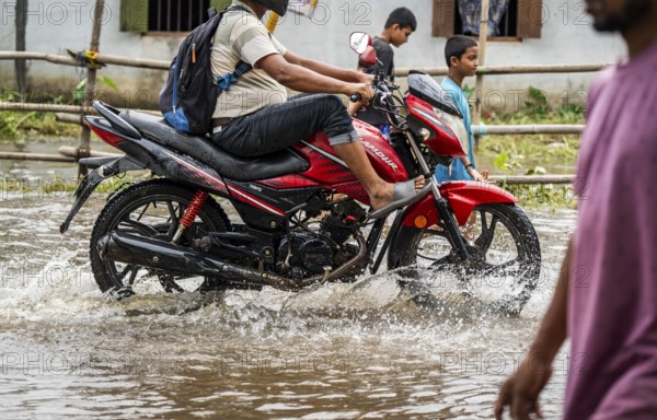 Commuters passing through a waterlogged street following heavy rainfall in Guwahati, India, on 1 June 2025, Asia