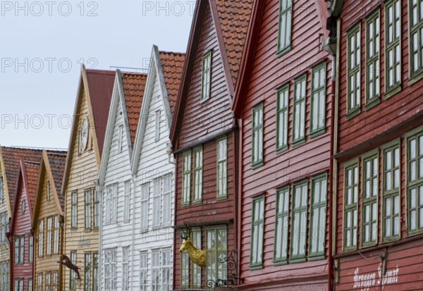 Row of colourful wooden houses with red roofs and rows of windows in Scandinavian style, Bergen, Norway, Europe