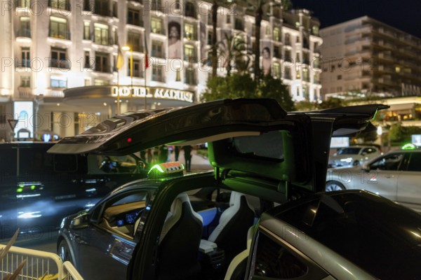 Cannes, France - 23 May 2024: A Tesla taxi stands in front of a hotel on the Promenade de la Croisette during the 78th Cannes International Film Festival. The film festival takes place from 13 to 24 May 2025