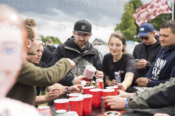 Festival visitors play a drinking game on a campsite at the Rock am Ring Festival on Saturday, Nürburgring race track race track, 07.06.2025