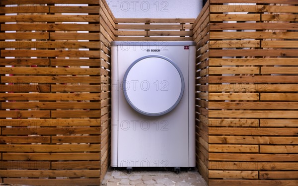 Bosch Compress 7400i AW air-to-water heat pump, logo, outdoor unit, building services, standing in front of garden fence, wooden fence, recess, Stuttgart, Baden-Württemberg, Germany, Europe