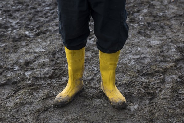 Festival visitors with yellow rubber boots in the mud at the Rock am Ring Festival on Sunday, Nürburgring race track race track, 08.06.2025