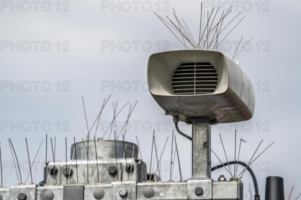 Loudspeakers on a scoreboard, at a railway station, studded with thin wires against birds, pigeons, to keep the technical equipment free of bird droppings, bird defence, pigeon defence