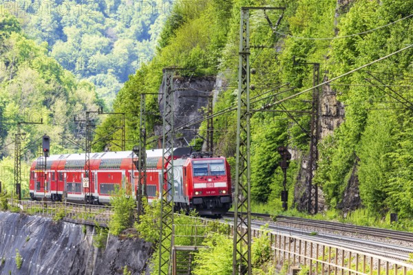 Regional express RE5 en route on the winding railway line of the Geislinger Steige. Landscape along the railway line in spring. Amstetten, Baden-Württemberg, Germany, Europe