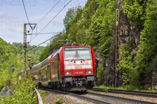 Regional express RE5 en route on the winding railway line of the Geislinger Steige. Landscape along the railway line in spring. Amstetten, Baden-Württemberg, Germany, Europe