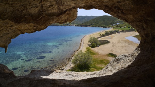 View from a rock cave onto a beach and the turquoise sea, Petra beach, cave, Grikos, rocks of Kalikatsou, Patmos, Dodecanese, Greek Islands, Greece, Europe
