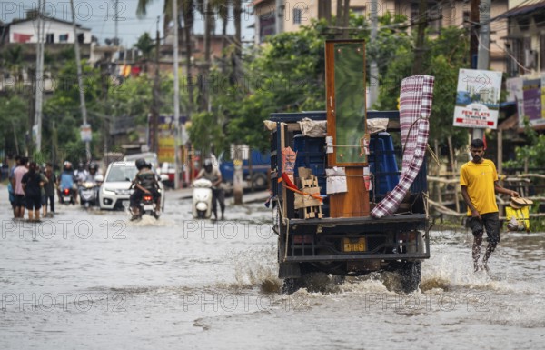 Commuters passing through a waterlogged street following heavy rainfall in Guwahati, India, on 1 June 2025, Asia