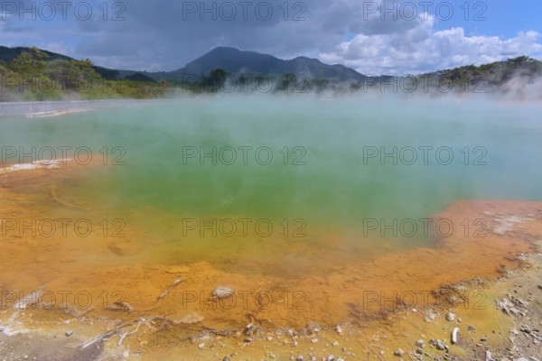 A geothermal area with steaming water and blue skies, Champagne Pool thermal lake, Wai-O-Tapu Thermal Wonderland, Rotorua, North Island, New Zealand, Oceania