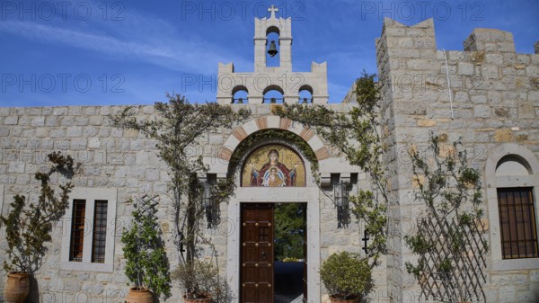 Stone building with bell tower and religious mosaic, surrounded by climbing plants, woman's monastery, Evangelismou Monastery, Patmos, Dodecanese, Greek Islands, Greece, Europe