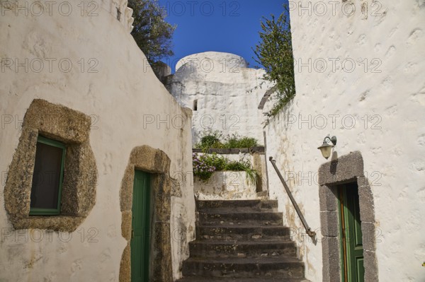 Whitewashed buildings with stone details and green doors under a clear blue sky, Monastery of the Revelation, Moni tis Apokalipsis, World Heritage Site 1999, Patmos, Dodecanese, Greek Islands, Greece, Europe